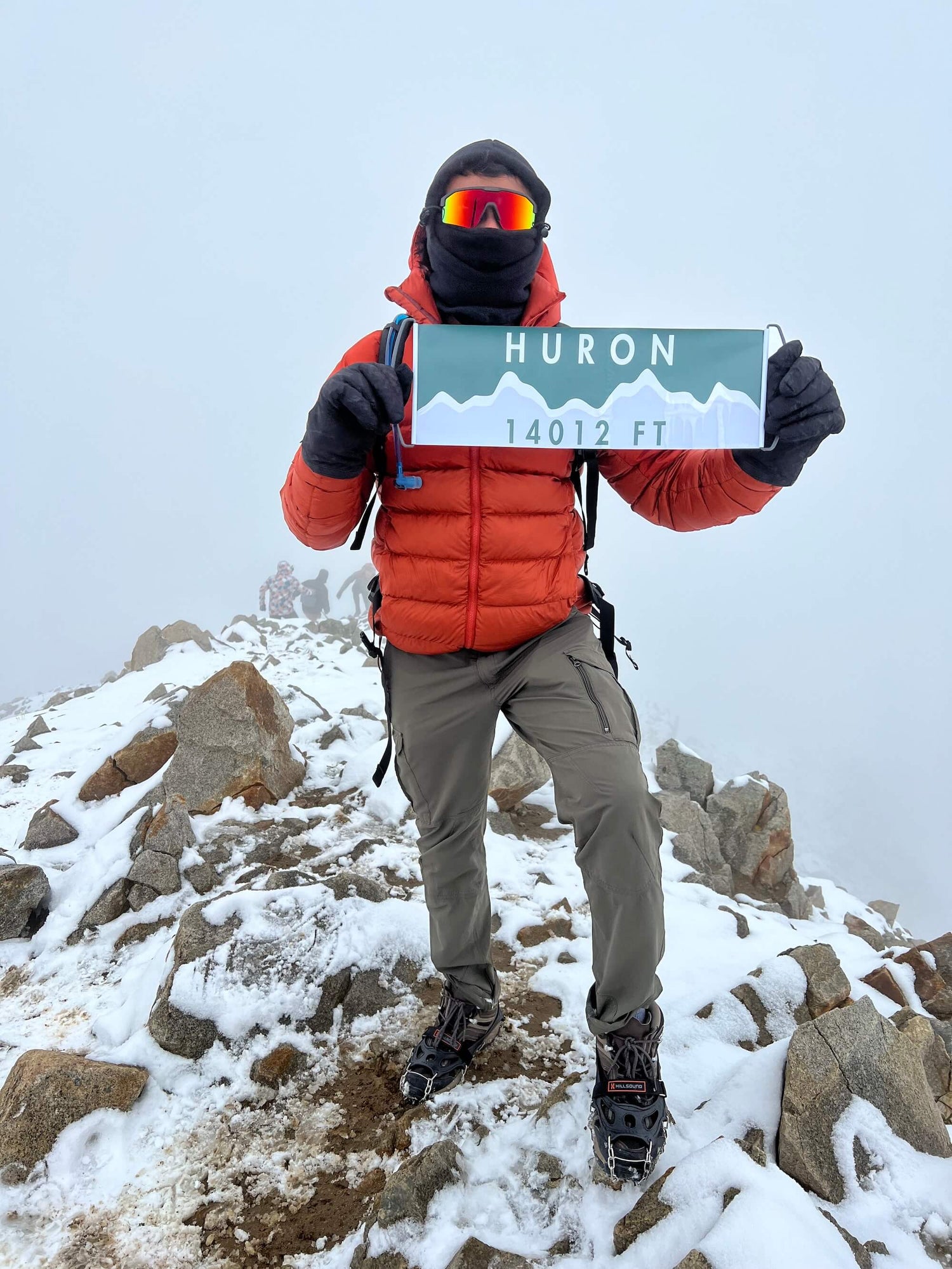 Mountaineer at the top of Mount Huron with their Summiter Mountain Flag