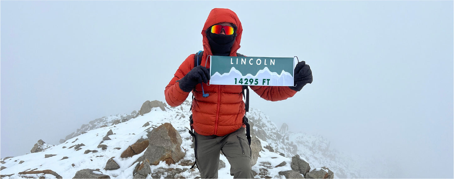 Mountaineer on the top of Mount Lincoln with their Summiter Mountain Girl