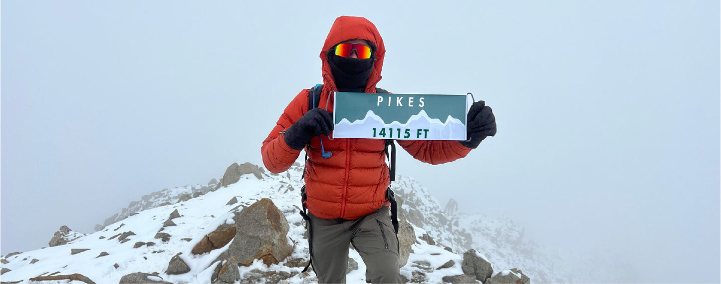 High Altitude hiker on the summit of Pikes Peak with their Summiter Mountain Flag